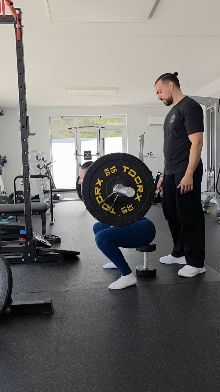 Anthony Ciccarelli osserva una cliente durante uno squat su box